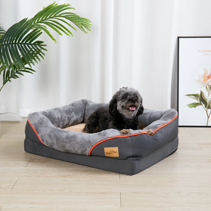A dog resting on an orthopaedic foam dog bed with a grey cover and orange detailing.