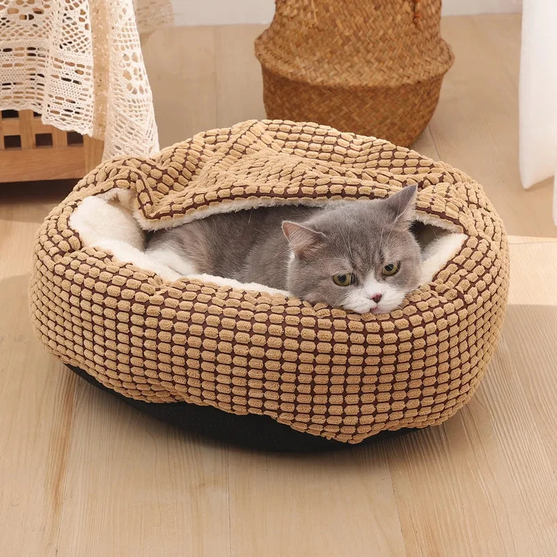 Cat lying in a beige knitted pet bed on a wooden floor.