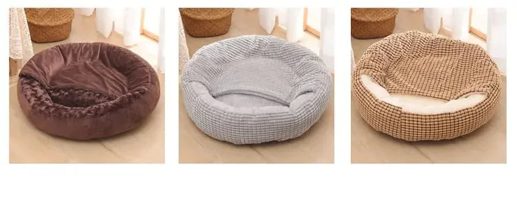 Three round pet beds in different colors on a light wooden floor.
